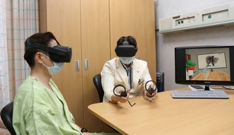 삼성서울병원 암병원 간암센터 유진수교수가 VR 기기를 이용해 환자에게 수술 설명을 하고 있다
